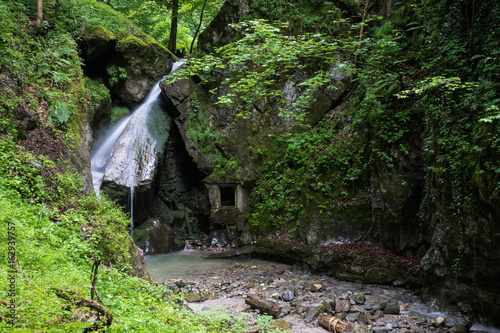 Obraz na płótnie kleiner Wasserfall mit Felsenfenster w salonie