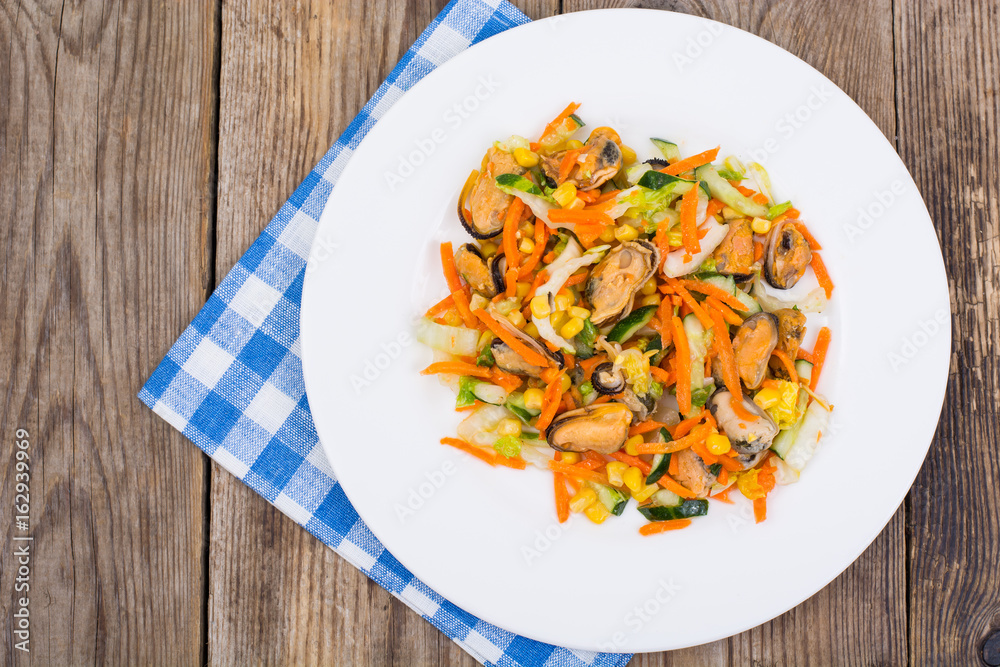 Peking cabbage, corn, cucumber, mussels on a white saucer on an 
