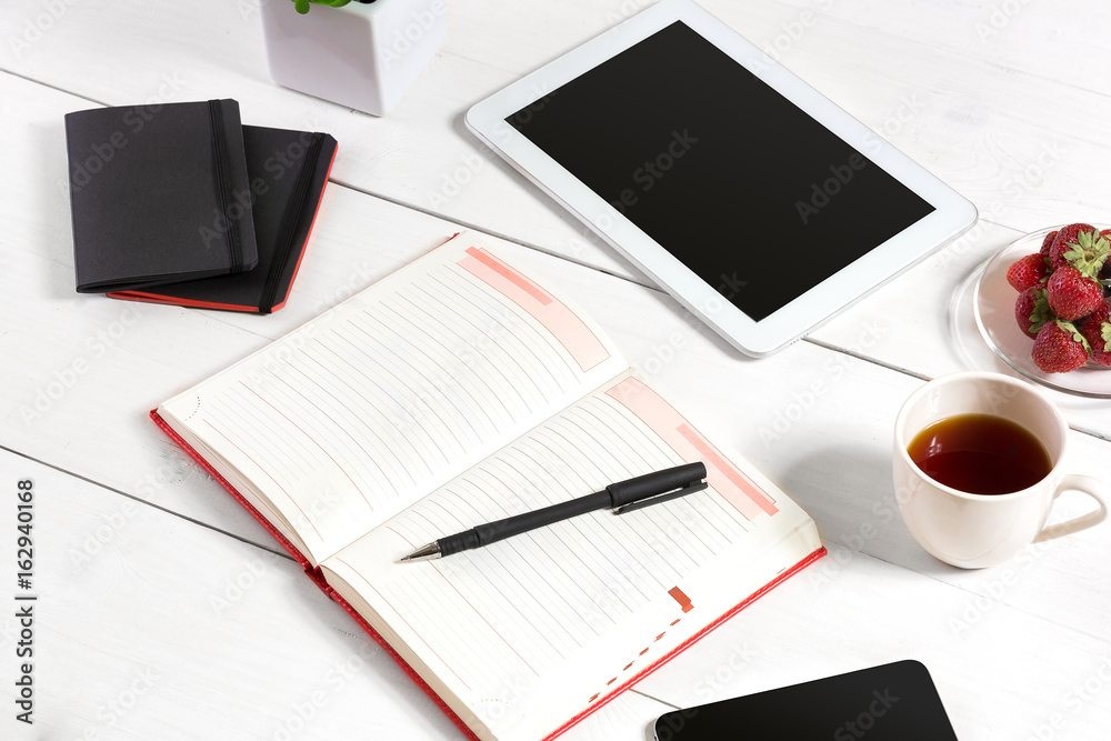 Stylish minimalistic workplace with tablet and notebook and glasses in flat lay style. White background. Stylish minimalistic workplace with tablet and notebook and glasses in flat lay style. White background.