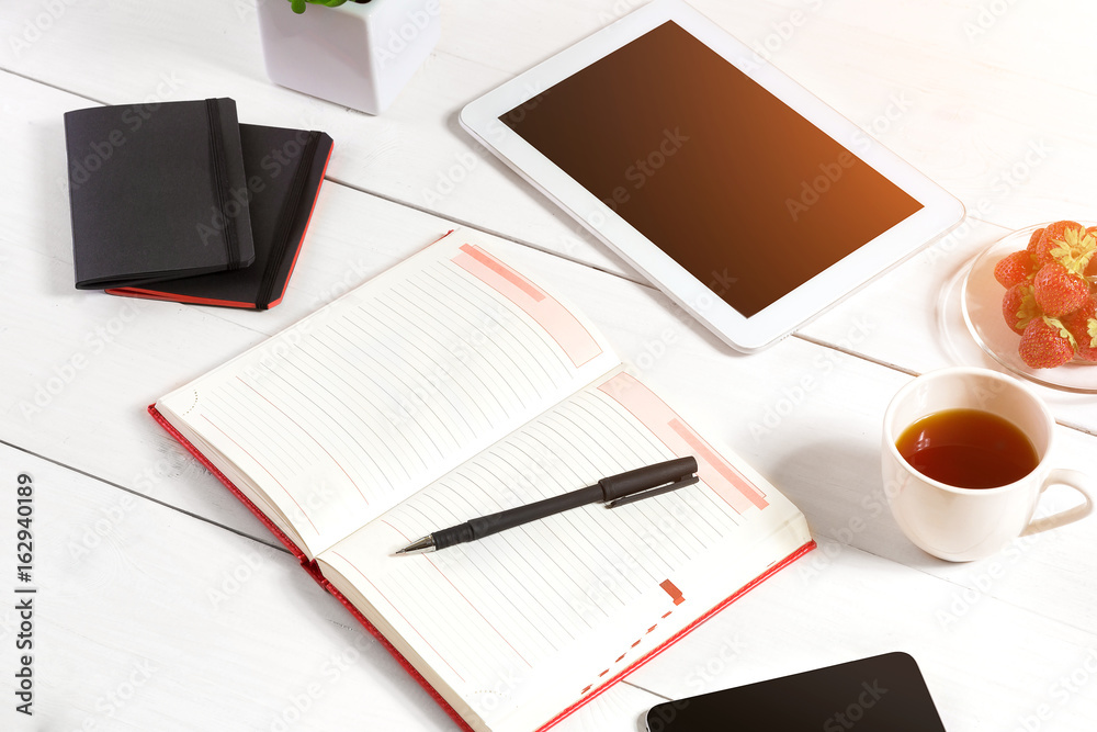 Stylish minimalistic workplace with tablet and notebook and glasses in flat lay style. White background. Stylish minimalistic workplace with tablet and notebook and glasses in flat lay style. White background.