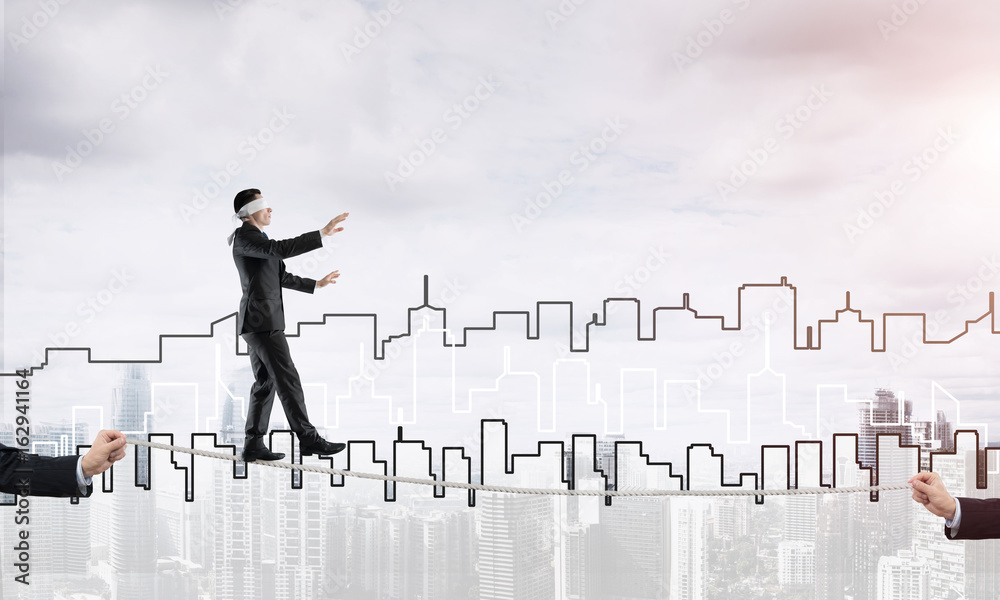 Business concept of risk support and assistance with man balancing on rope Business concept of risk support and assistance with man balancing on rope