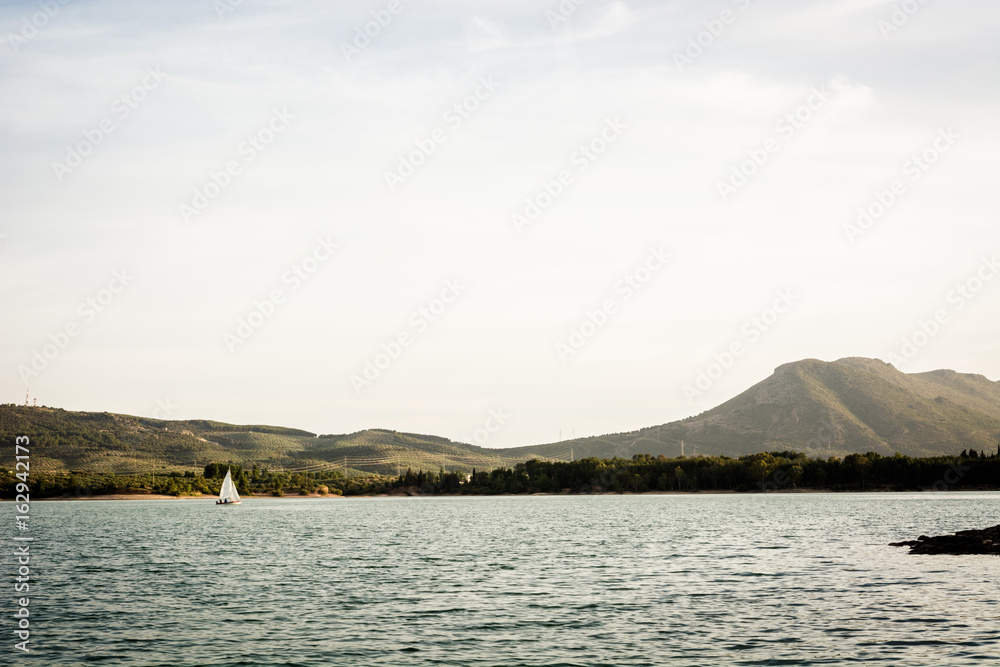 Small ship sailing on a lake at the afternoon