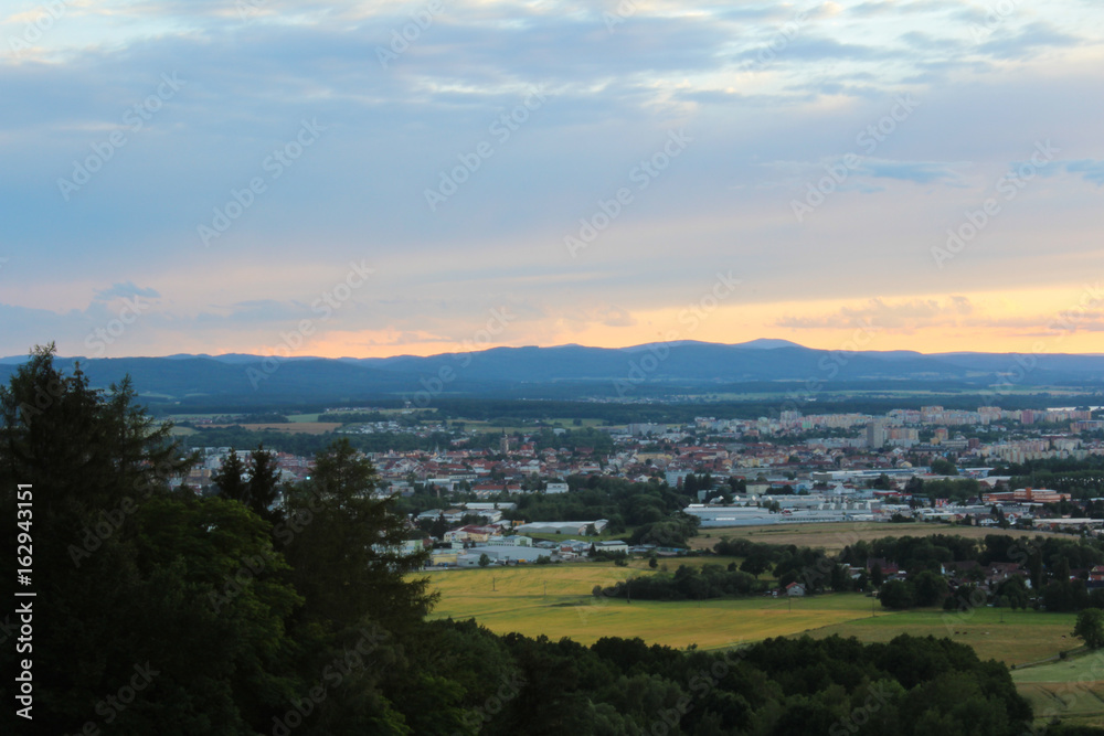 Panoramatic view on city Ceske Budejovice in sunset with trees