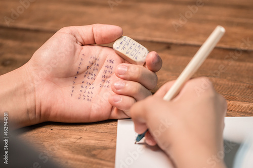 People cheating on test by writing answer on eraser photo