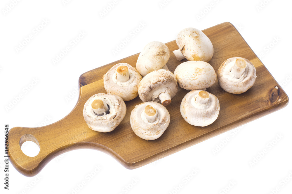Champignons on kitchen wooden cutting board. Champignons on kitchen wooden cutting board.