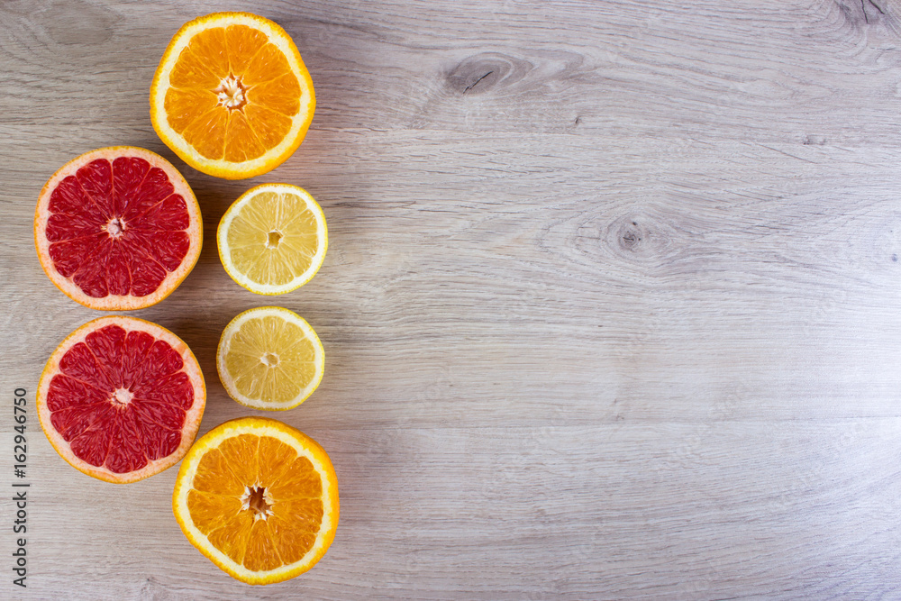 Citrus fruits cut background- oranges, lemons, grapefruit on a bright wooden background Citrus fruits cut background- oranges, lemons, grapefruit on a bright wooden background