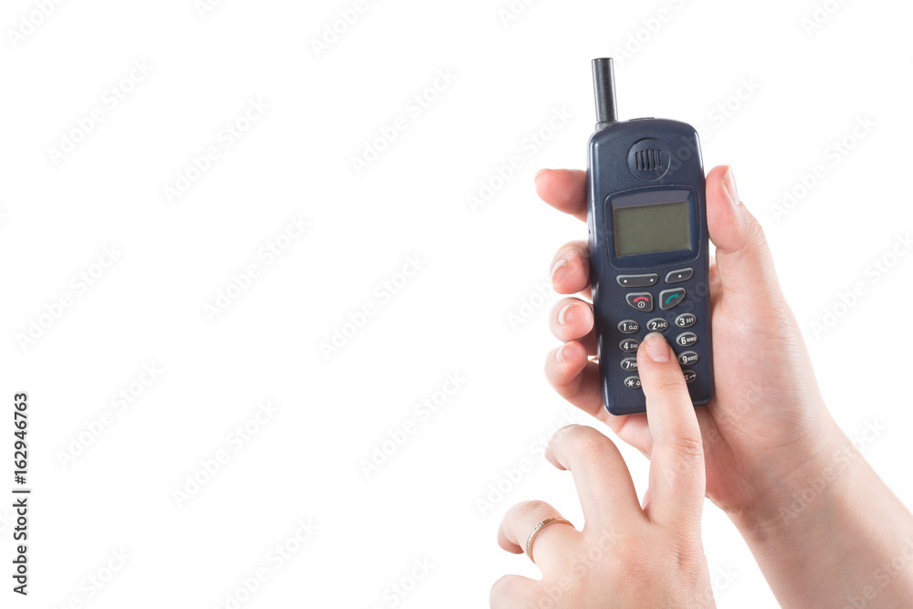 Woman hand holding old mobile phone and presses buttons isolated on white background Woman hand holding old mobile phone and presses buttons isolated on white background