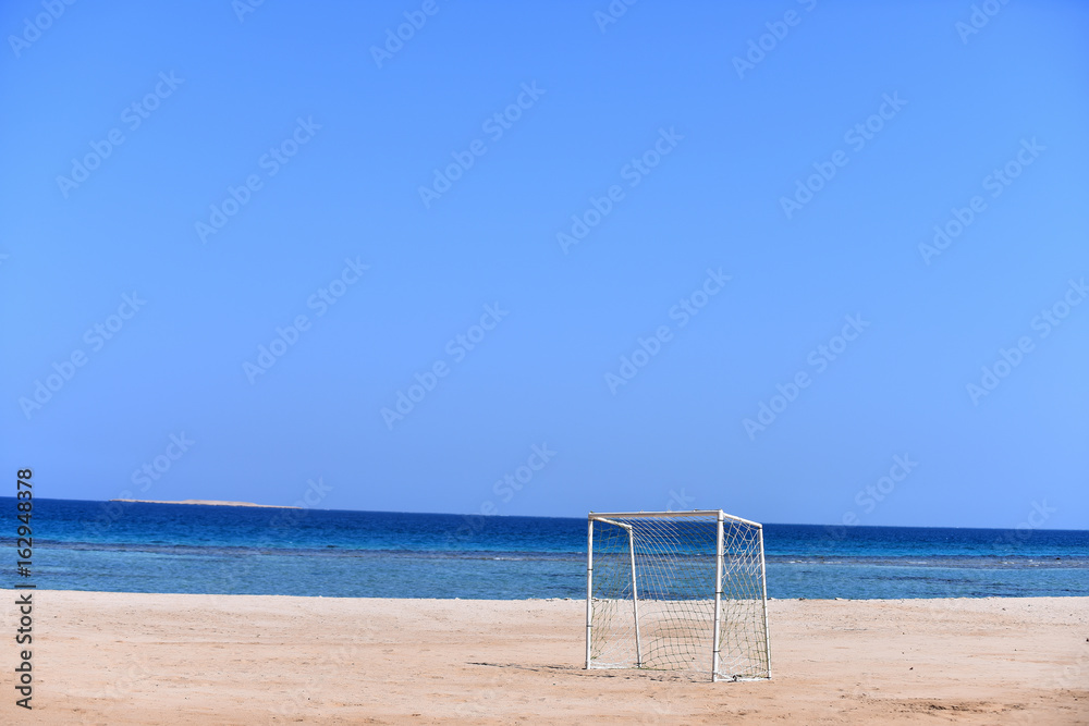 Soccer goal on background of blue sky and sea