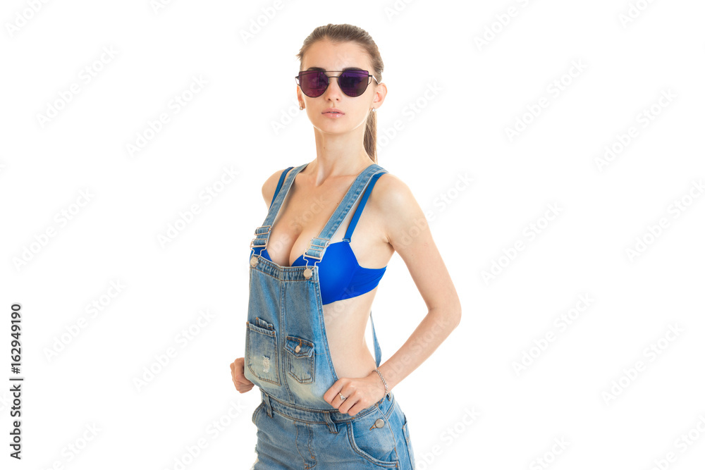 fashionable young girl in mirror glasses and jeans dress posing in front of a camera fashionable young girl in mirror glasses and jeans dress posing in front of a camera