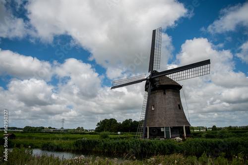 Dutch windmill with cloudy sky in the summer