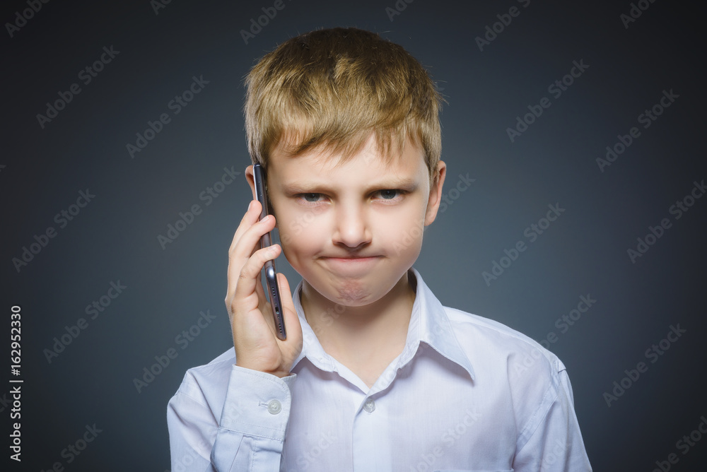 Portrait of offense boy with mobile or cell phone. Negative human emotion Portrait of offense boy with mobile or cell phone. Negative human emotion