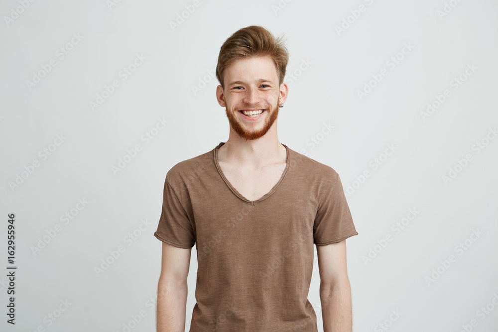 Portrait of happy cheerful young man with beard smiling looking at camera over white background. Portrait of happy cheerful young man with beard smiling looking at camera over white background.