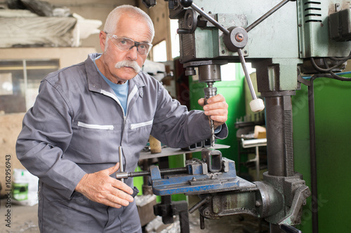milling machine operator working in factory workshop