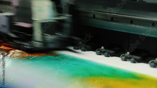 Printing head creates colorful image on paper in machine