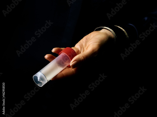 woman hand isolated on black showing sample jar © Alliance