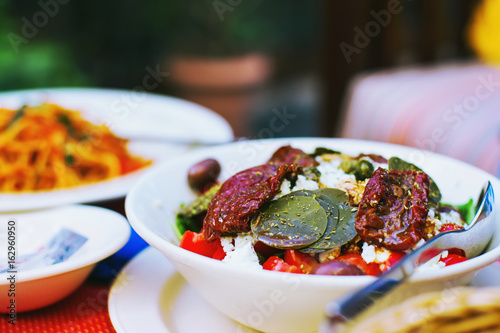 Healthy vegan food - closeup of salad with sundried tomatoes, capers leaves. photo