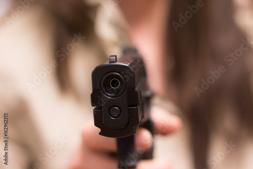 Mujer apuntando con una pistola photo