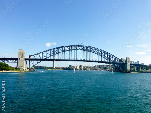 Harbour bridge leading from Syndey on a clear day with sailboats © Jason