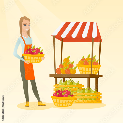 Greengrocer holding box full of apples.