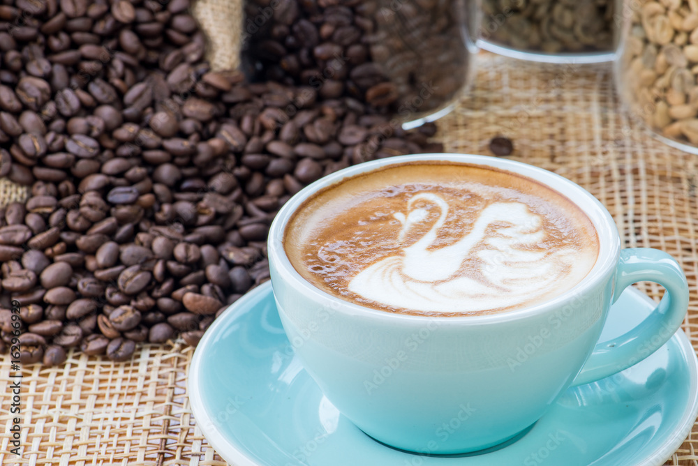 Cup of coffee on coffee beans background on a wooden table Cup of coffee on coffee beans background on a wooden table