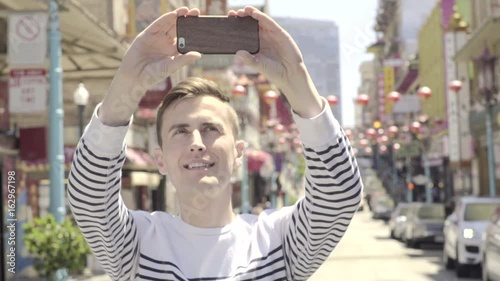 Tourist Uses His Smart Phone And Takes A Panorama Of Chinatown, San Francisco 