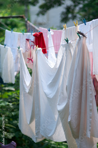 Linen out to dry on the rope.Washing hanging exposed to sunlight.Laundry hanging in a garden/Laundry line with clothes line in garden © sleto