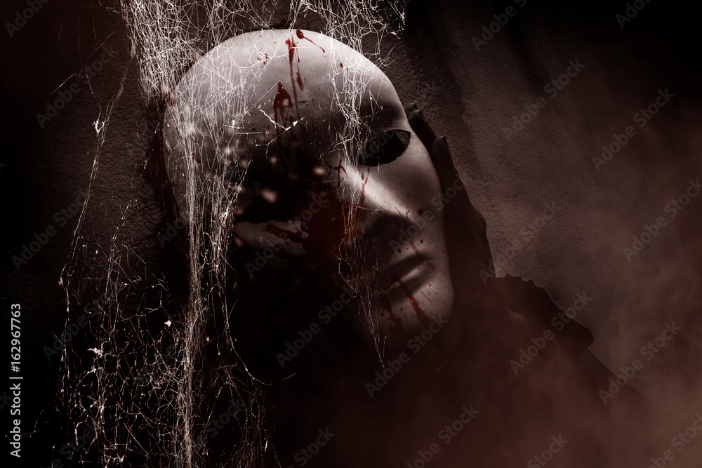 Fototapeta premium Mysterious woman in black wearing white mask hidden behind spider web,Scary background for book cover