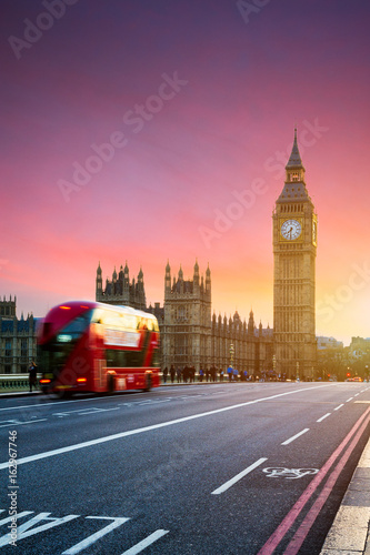 London, the UK. Red bus in motion and Big Ben, the Palace of Westminster. The icons of England