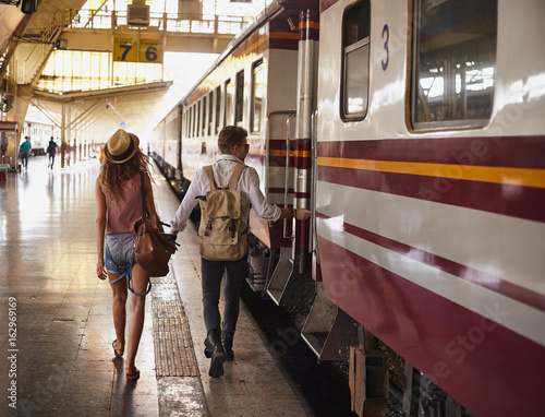 Young couple walking at the train station platform during train car