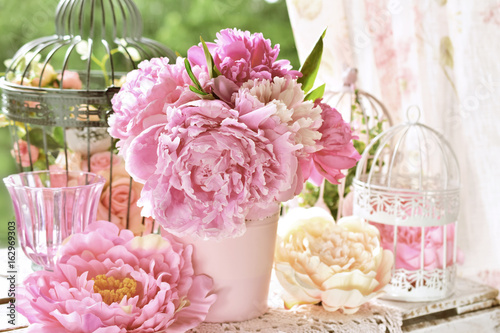 peony bunch in vase on the table in the garden with color effect