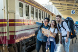 Multiethnic Travellers are looking at train and holding the map with happiness action at the train station, Travel and transportation concept