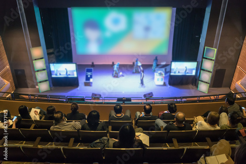 Speakers on the stage with Rear view of Audience in the conference hall or seminar meeting  business and education about investment concept