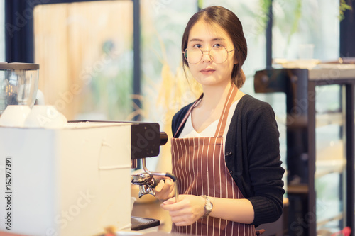 Asian barista woman making latte art at coffee shop,equipment,cafeteria people and technology concept