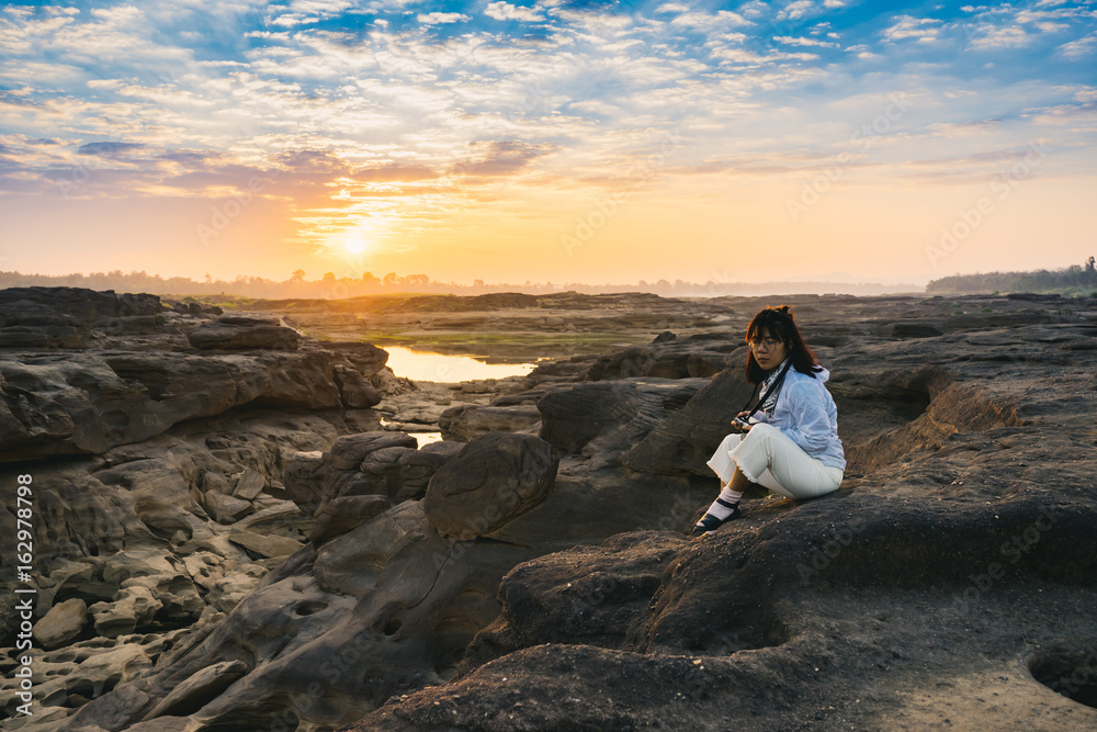 Women with white shirt sitting on a rock in Thailand stone canyon or Sam Pan Boak. Ubonratchathani Province ,Thailand Women with white shirt sitting on a rock in Thailand stone canyon or Sam Pan Boak. Ubonratchathani Province ,Thailand