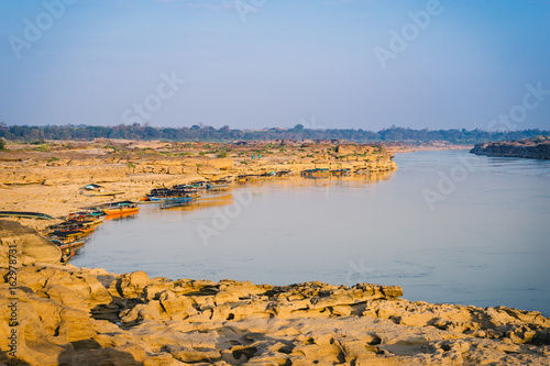 Boat docked in Mekong river near Sam Pan Bok canyon in Ubon Ratchathani , Thailand. photo