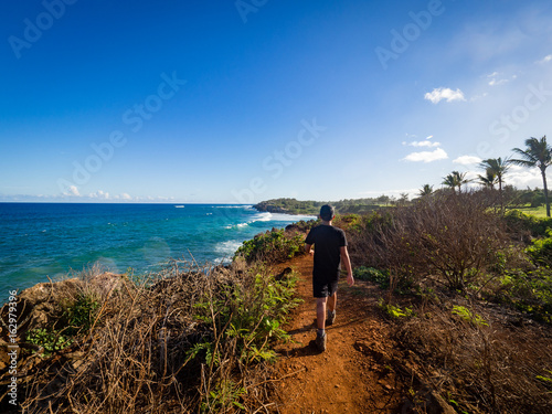10 year old boy hiking on Maha' elepu Heritage Trail, near Shipwreck Beach and Poipu Golf Course, Koloa, Kauai, Hawaii, USA
