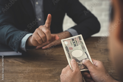 Businessman refusing money, Japanese yen bills