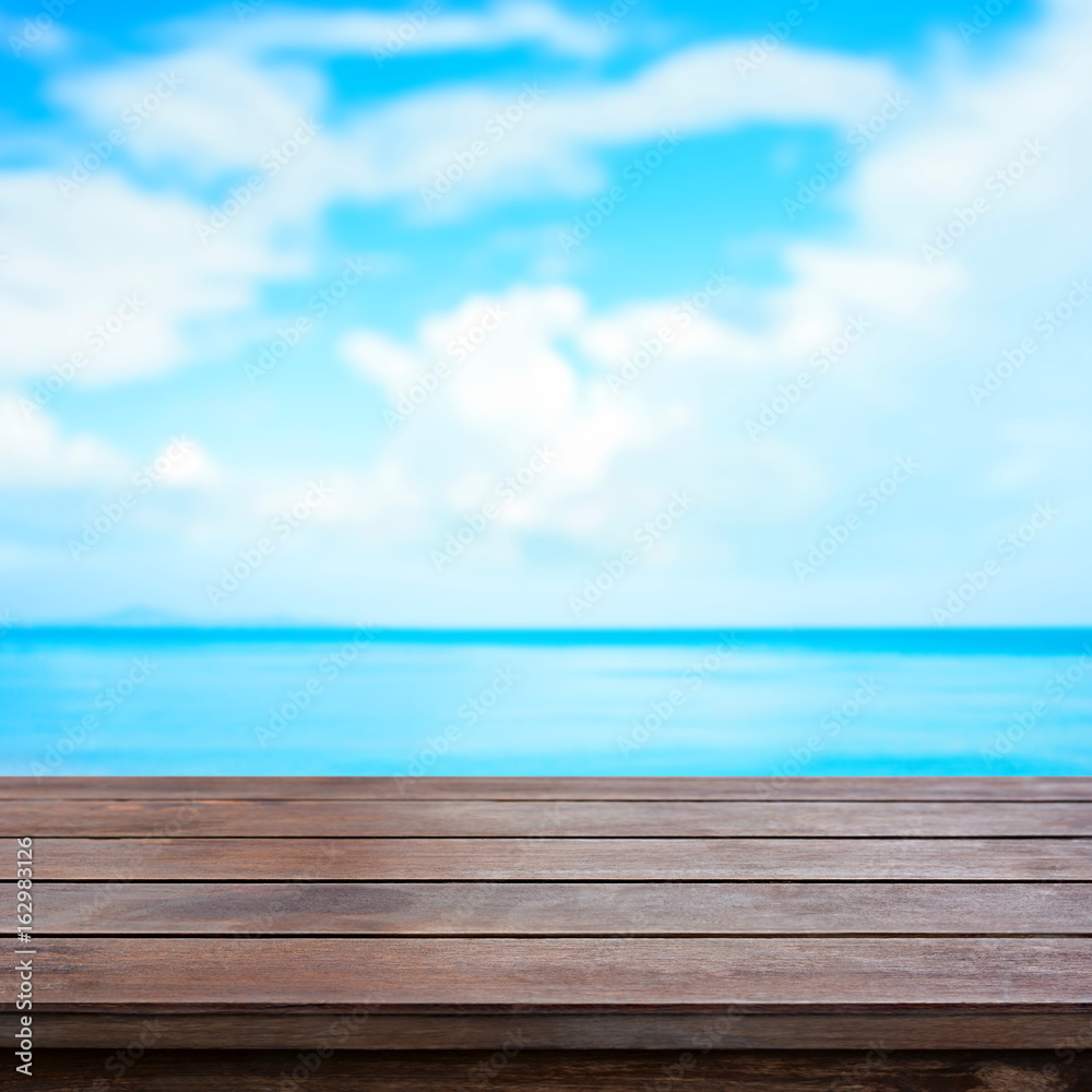 Old brown wood table top on blur sea and summer sky background