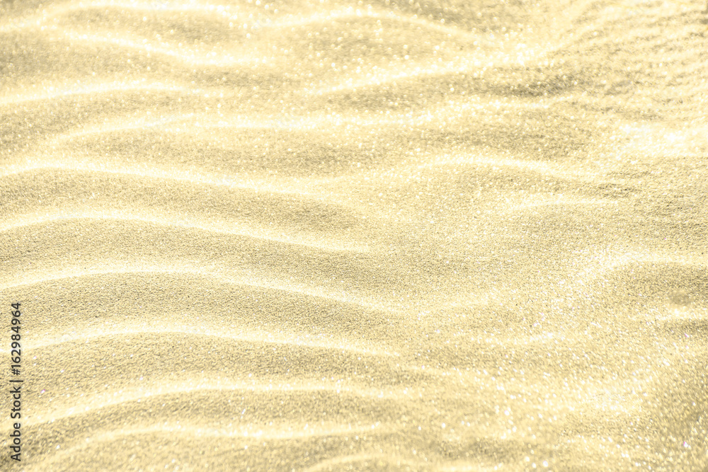Golden glitter on sand background Golden glitter on sand background