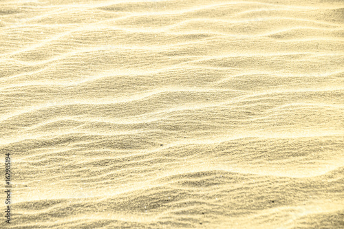 Golden glitter on sand background