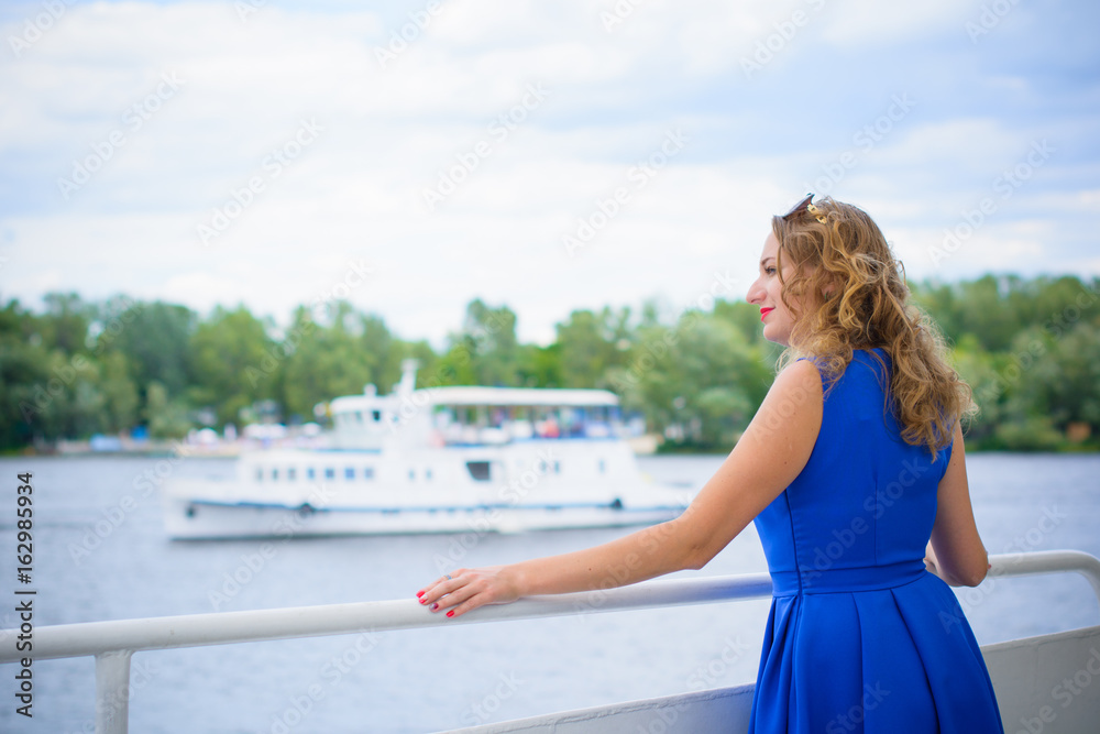 Women European appearance with blonde curly hair and blue eyes resting aboard on a balcony with iron hammered flowers at  water  beauty atmosphere
