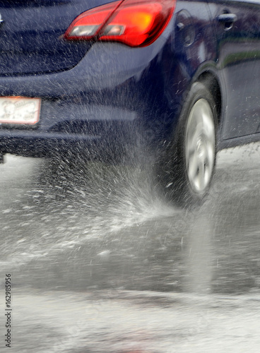 Car wheel moves fast on a very wet road.
