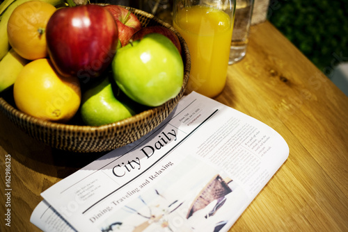 Closeup of fruits and newspaper on wooden table