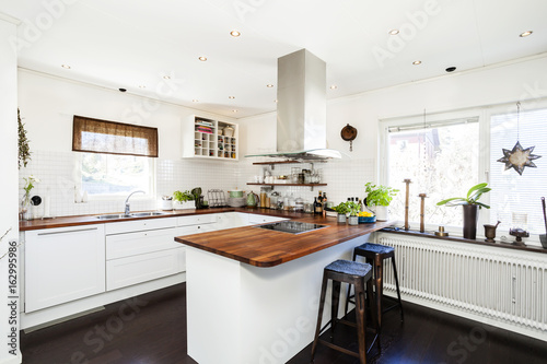 stylish kitchen interior with dark wooden floor white cupboards © annaia