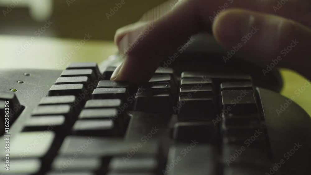 Male hand taping on the computer's keyboard Male hand taping on the computer's keyboard