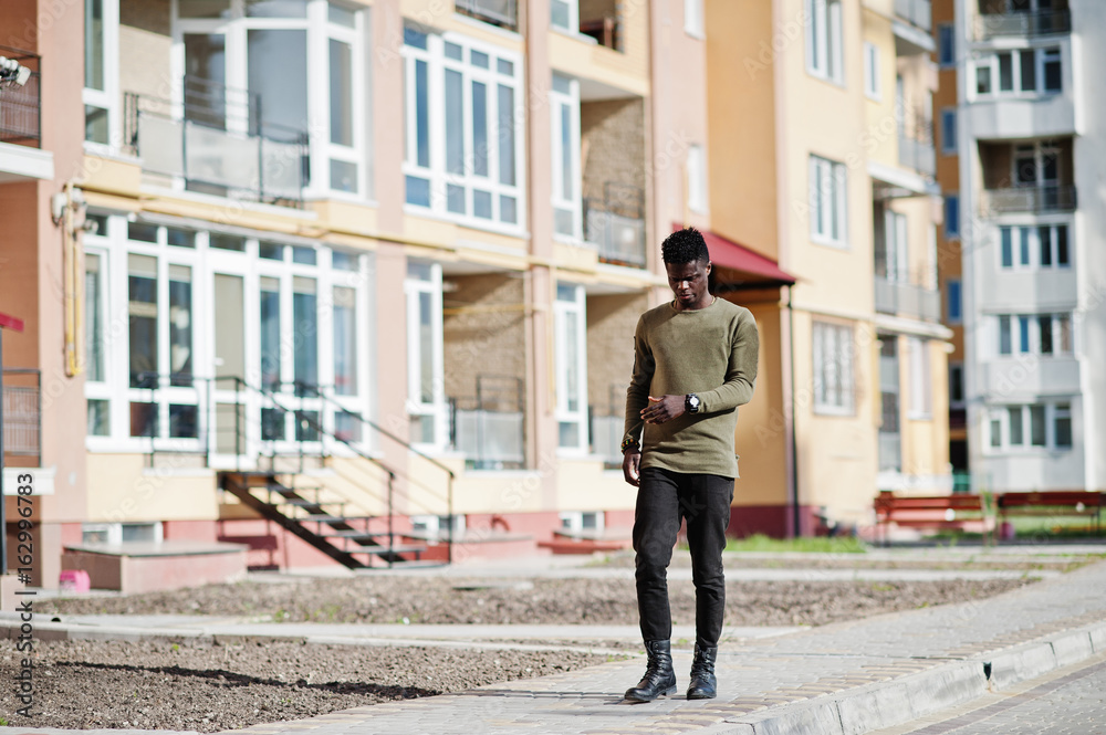 Handsome and attractive african american man posing next to the tall building on a street. Handsome and attractive african american man posing next to the tall building on a street.