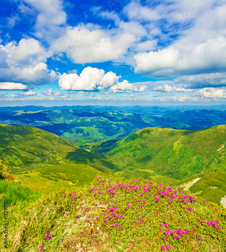 Panoramic view of the sky and mountain ridges from the top of the mountain in a sunny summer day