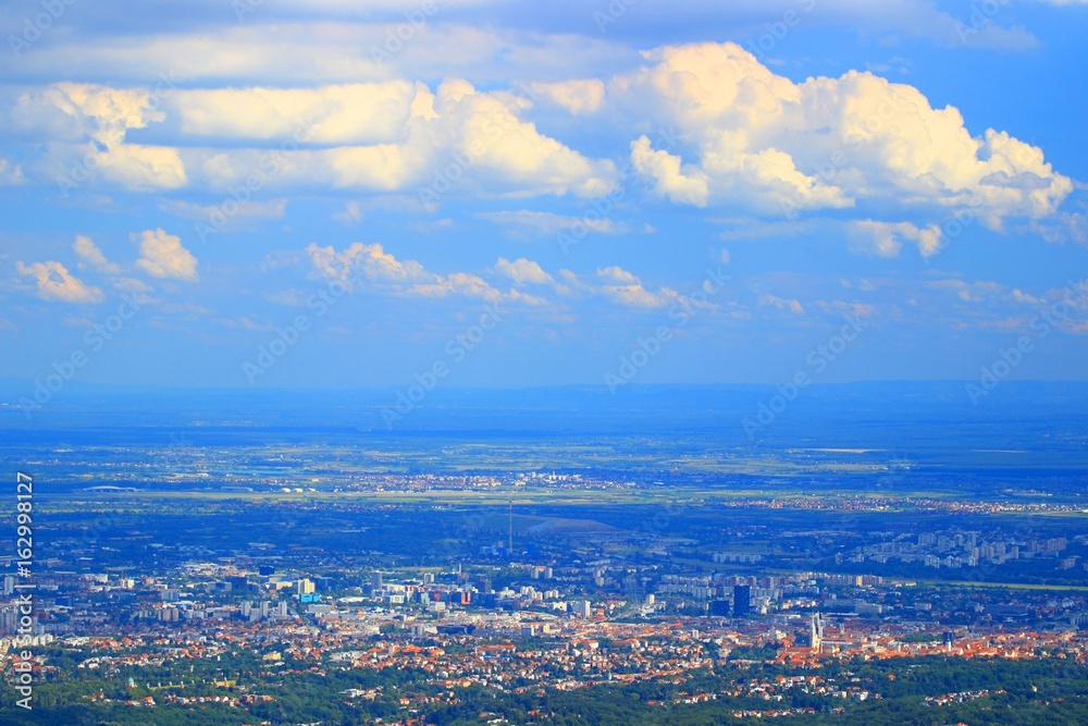 Zagreb, capital of Croatia, panoramic view form Medvednica mountain, cumulus clouds on blue sky