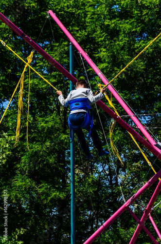 Little boy playing on bungee trampoline