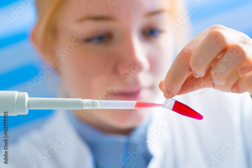 Laboratory assistant in the medical laboratory control a microbiological analysis of the blood. Using a pipette and a test tube in the laboratory